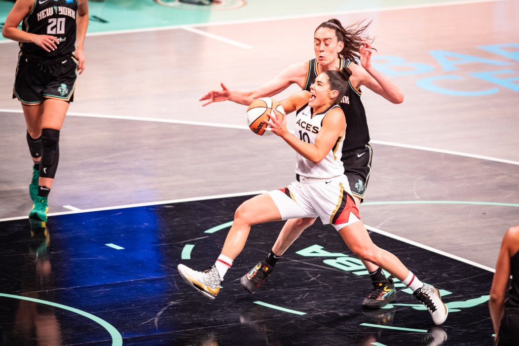 Las Vegas Aces guard Kelsey Plum drives down the lane to the basket with New York Liberty forward Breanna Stewart trailing her.