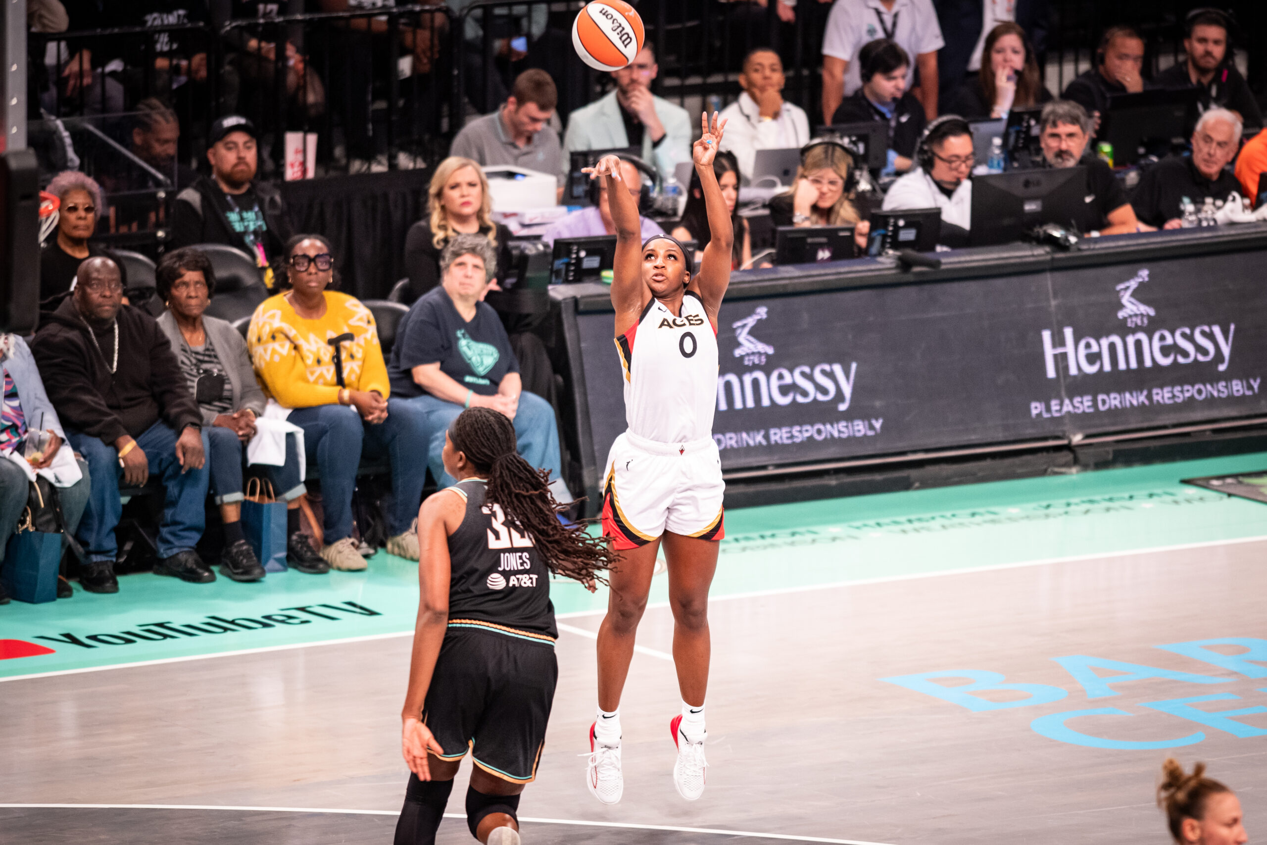 Las Vegas Aces guard Jackie Young shoots a three-pointer over New York Liberty defender Jonquel Jones.