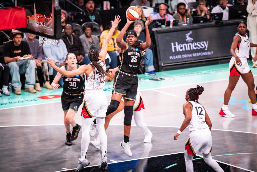 New York Liberty forward Jonquel Jones shoots a right-handed midrange jump shot over Las Vegas Aces center Kiah Stokes.