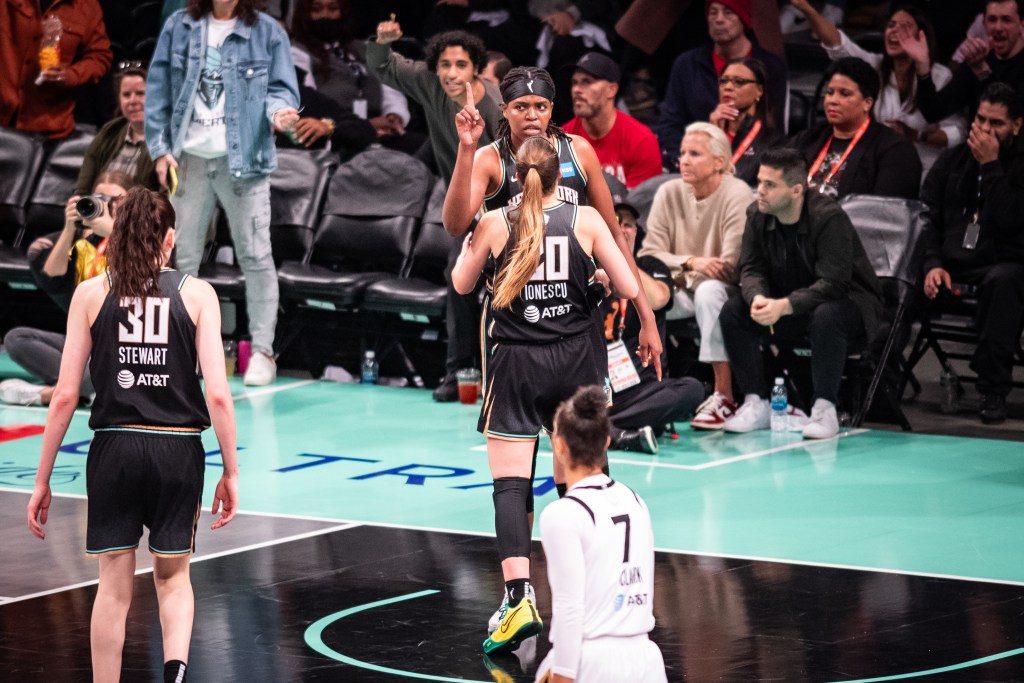 Liberty forward Jonquel Jones has her finger up as teammate Sabrina Ionescu approaches her. 