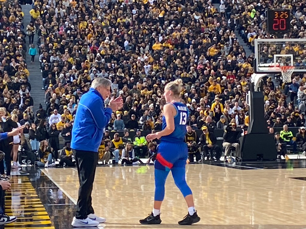 DePaul head coach Doug Bruno stands on the sideline and talks with guard Maeve McErlane.
