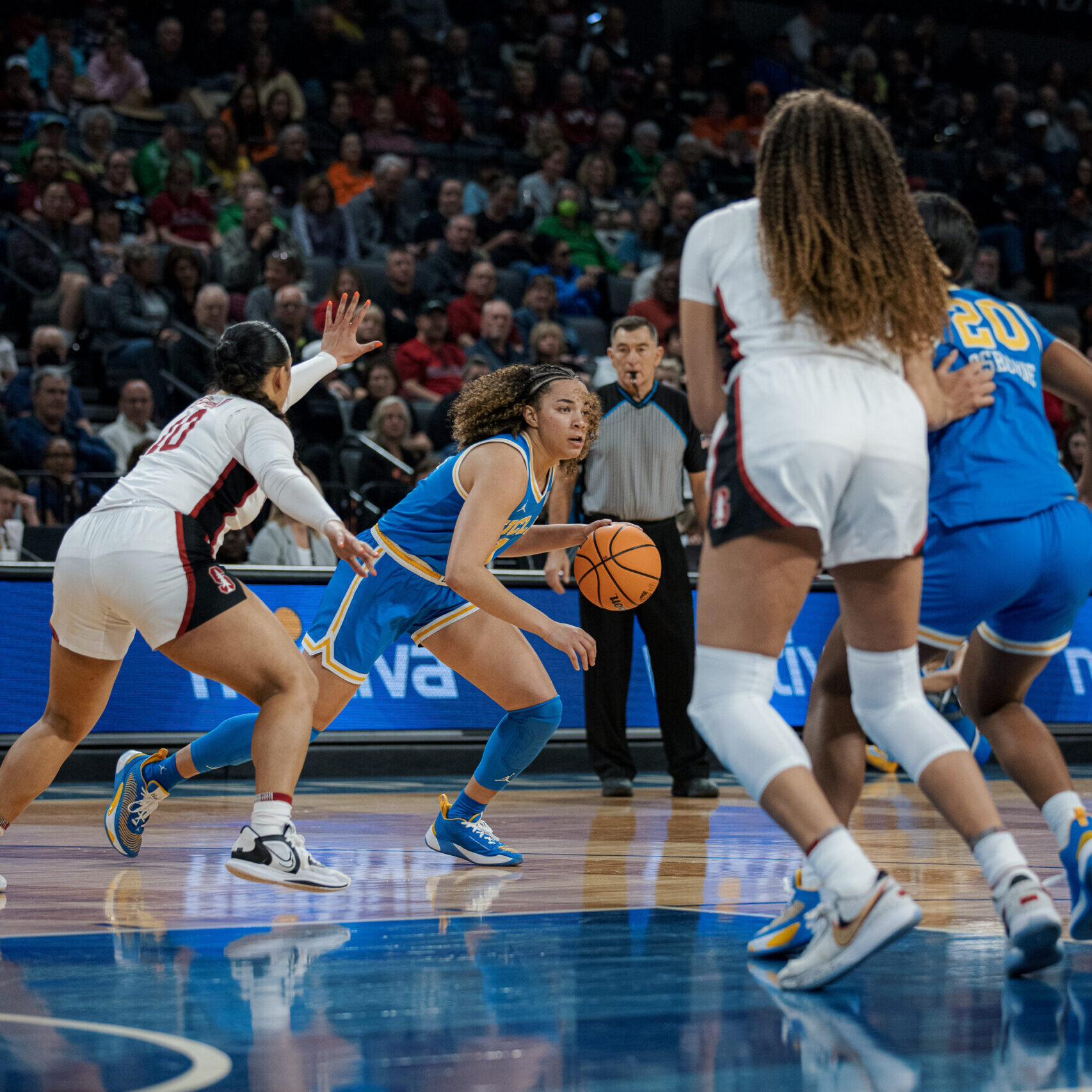 UCLA's Kiki Rice dribbling away from an opponent during a Pac 12 matchup with Stanford.