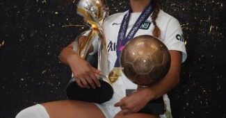 Gotham FC forward Midge Purce celebrates an NWSL title while holding two trophies and smoking a cigar.