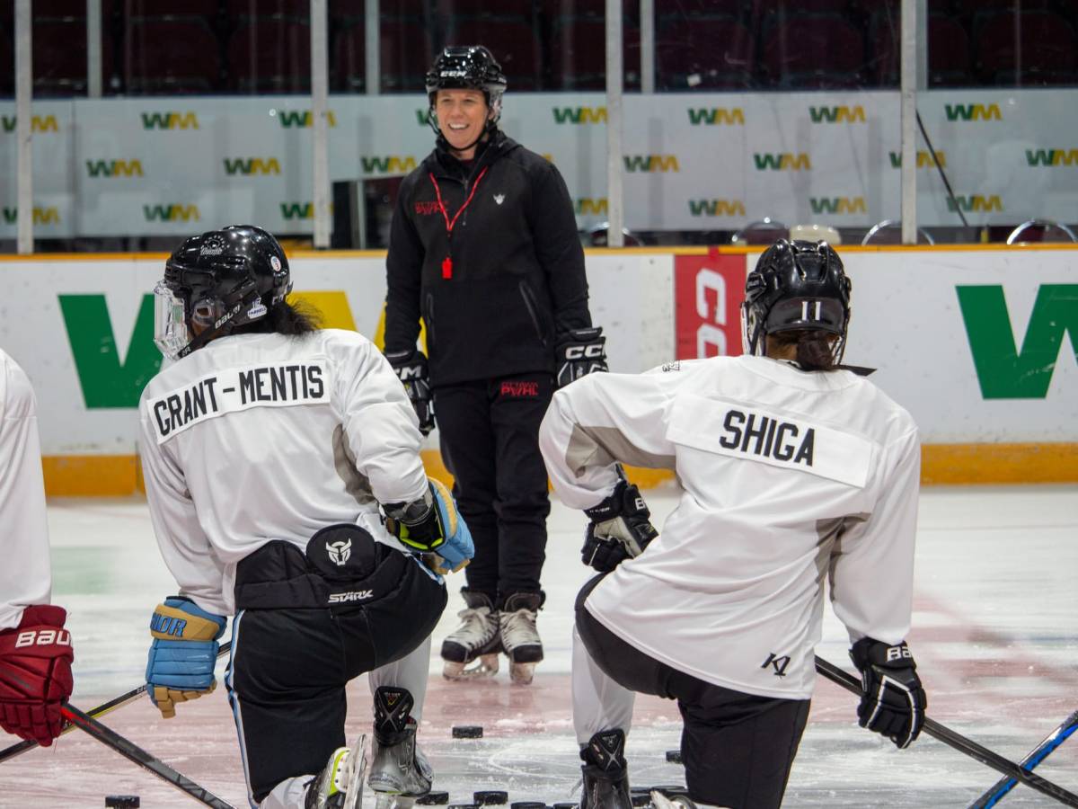 Grant-Mentis and Shiga kneel on the ice in front of head coach Carla MacLeod.