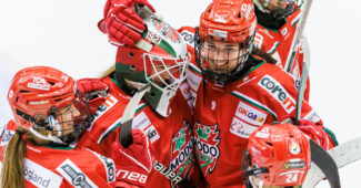 Taylor House is pictured celebrating on the ice alongside SDHL teammates. They are wearing the team's red and white uniforms.