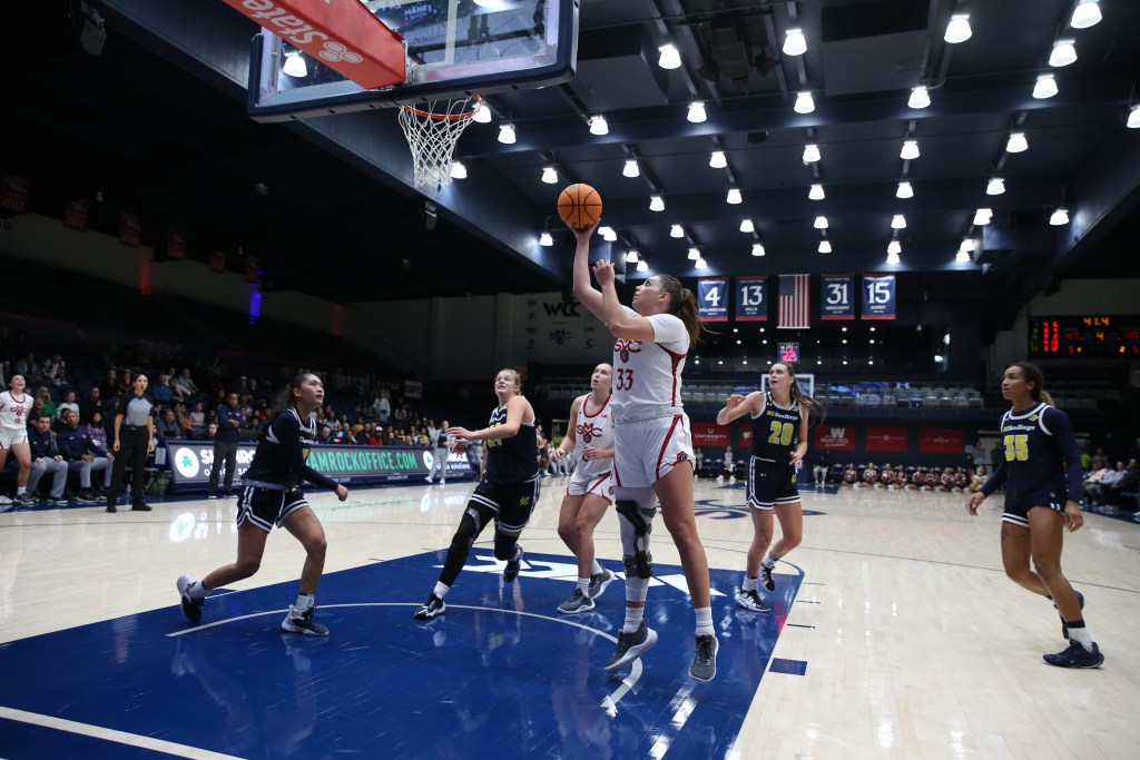 Saint Mary's forward Ali Bamberger shoots a wide-open layup on the left side of the basket with her right hand.