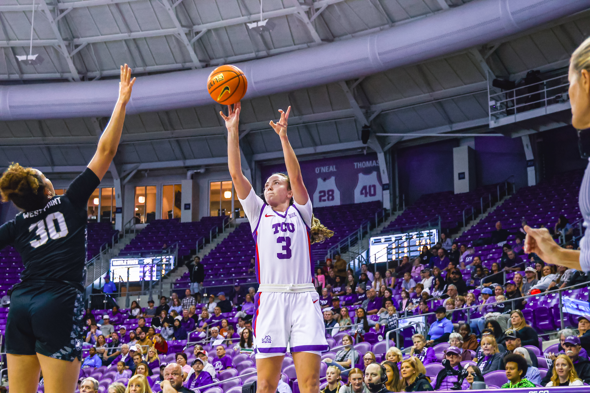 Madison Conner shoots a right-handed jump shot as an Army player arrives slightly late to contest it.