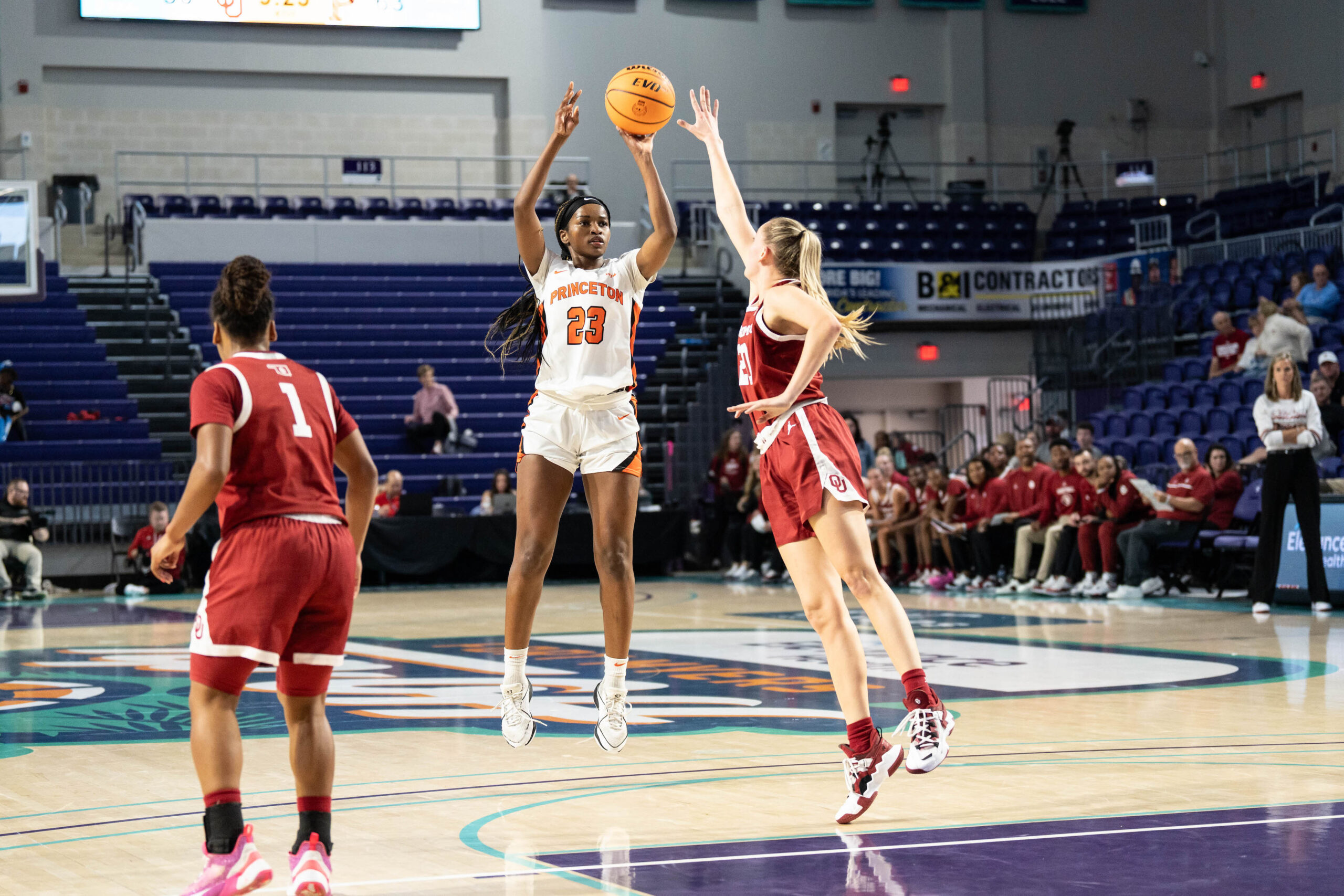 Princeton guard Madison St. Rose takes a left-handed jump shot from near the elbow. An Oklahoma defender jumps toward her with one arm outstretched to contest it.