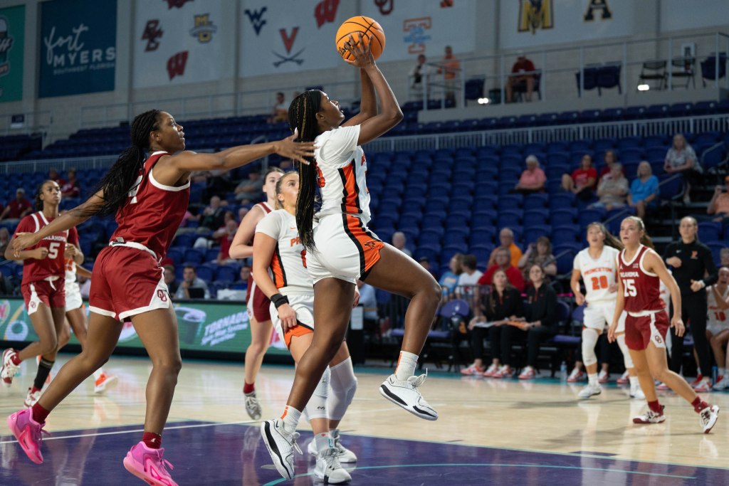 Princeton guard Madison St. Rose rises for a layup as an Oklahoma defender reaches toward her from behind, unable to contest the shot.