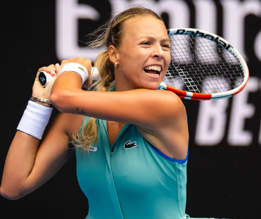 Anett Kontaveit of Estonia smiles on the court with her racket over her shoulder.
