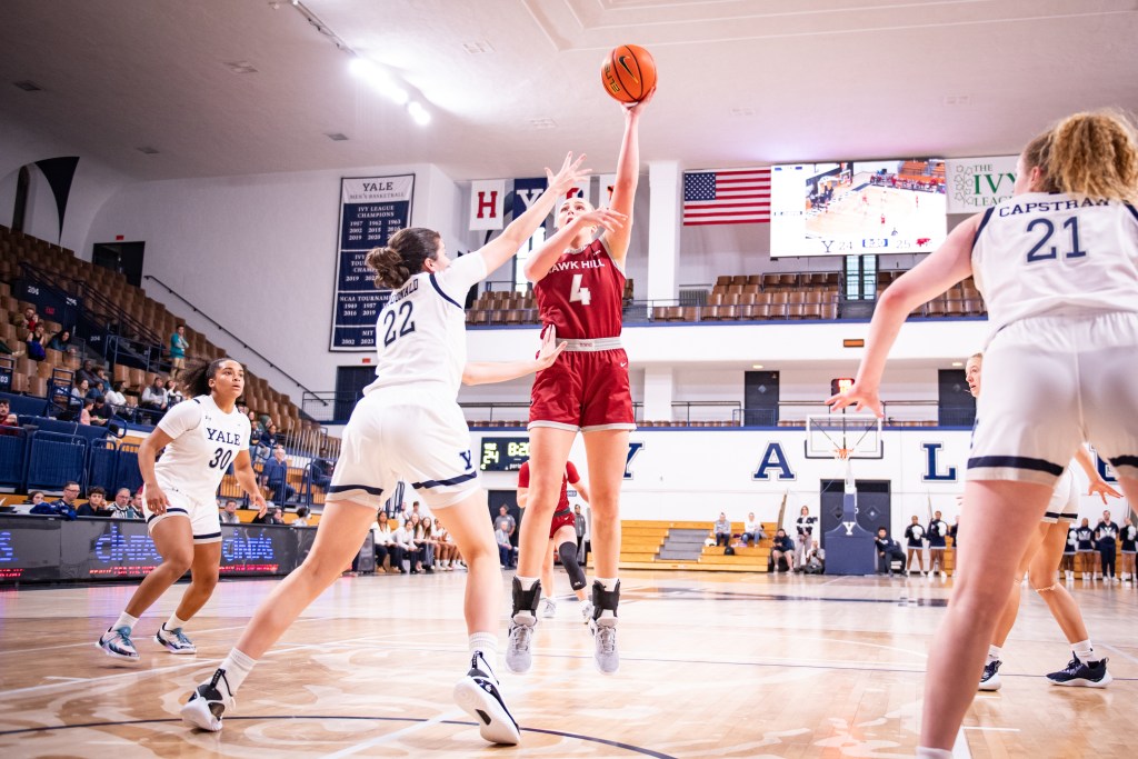 Saint Joseph's forward Laura Ziegler shoots near the restricted arc as a Yale defender steps up to contest and three other defenders look on.