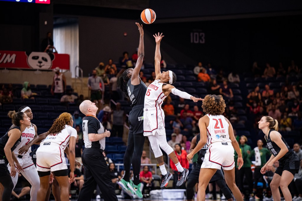 Washington Mystics guard Brittney Sykes battles with Seattle Storm big Ezi Magbegor to win the opening tip as their teammates look on.