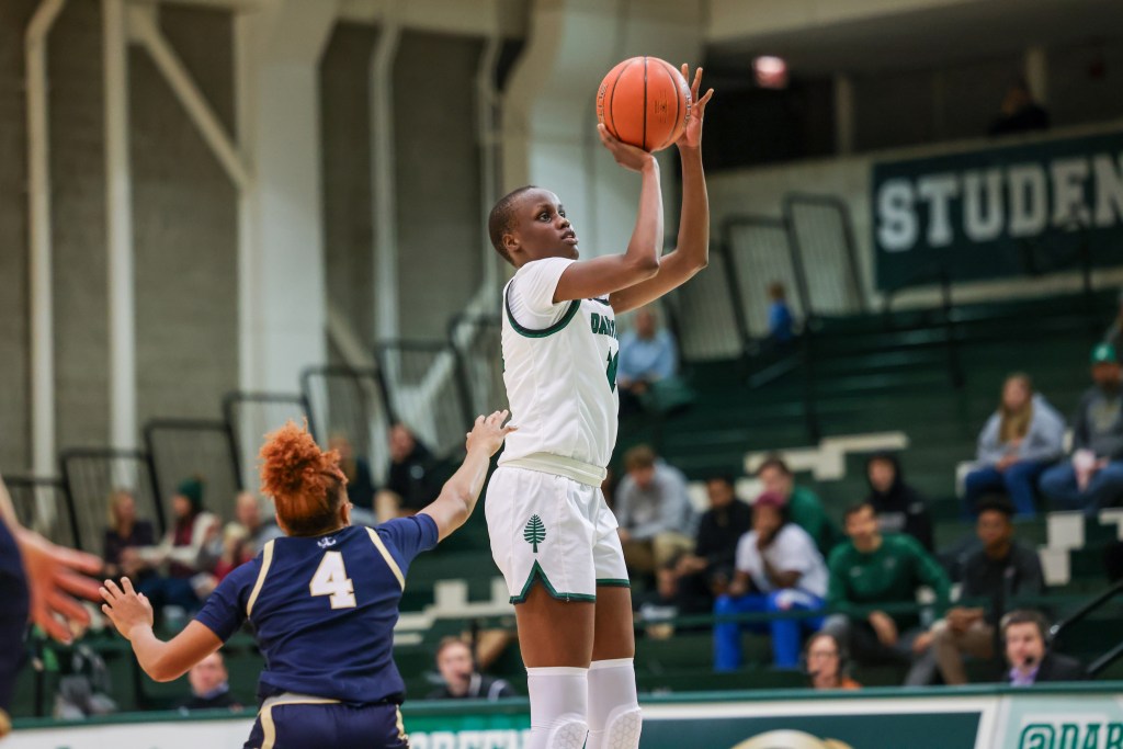 Dartmouth forward Doreen Ariik shoots an open right-handed jump shot. A Navy defender realizes Ariik is open but is too late to contest it.