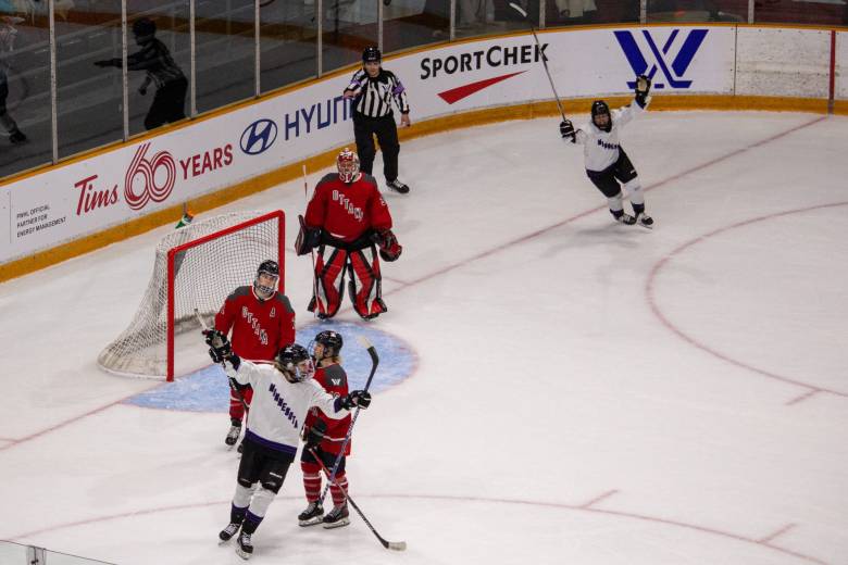 Two PWHL Minnesota players cheer while three PWHL Ottawa players hang their heads.