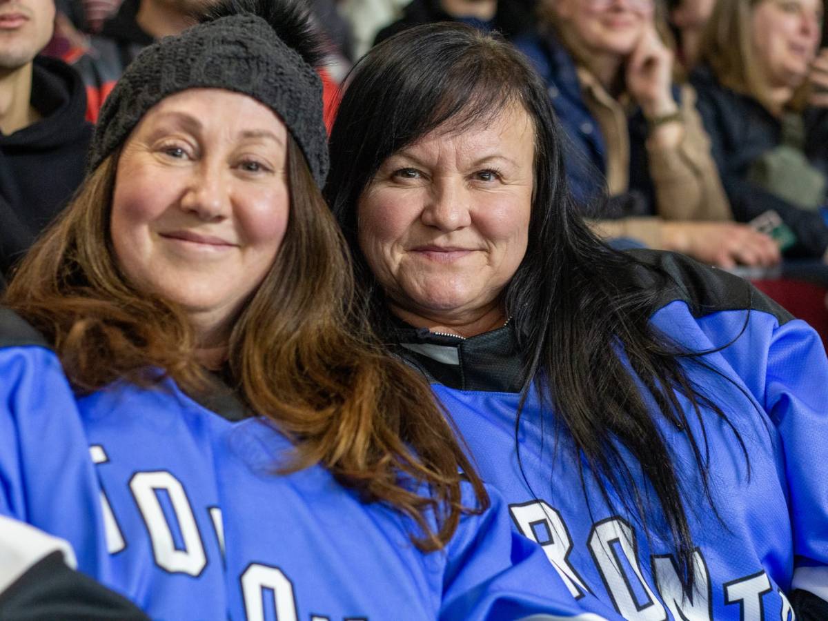 Two women wearing blue PWHL Toronto jerseys pose for a photo.