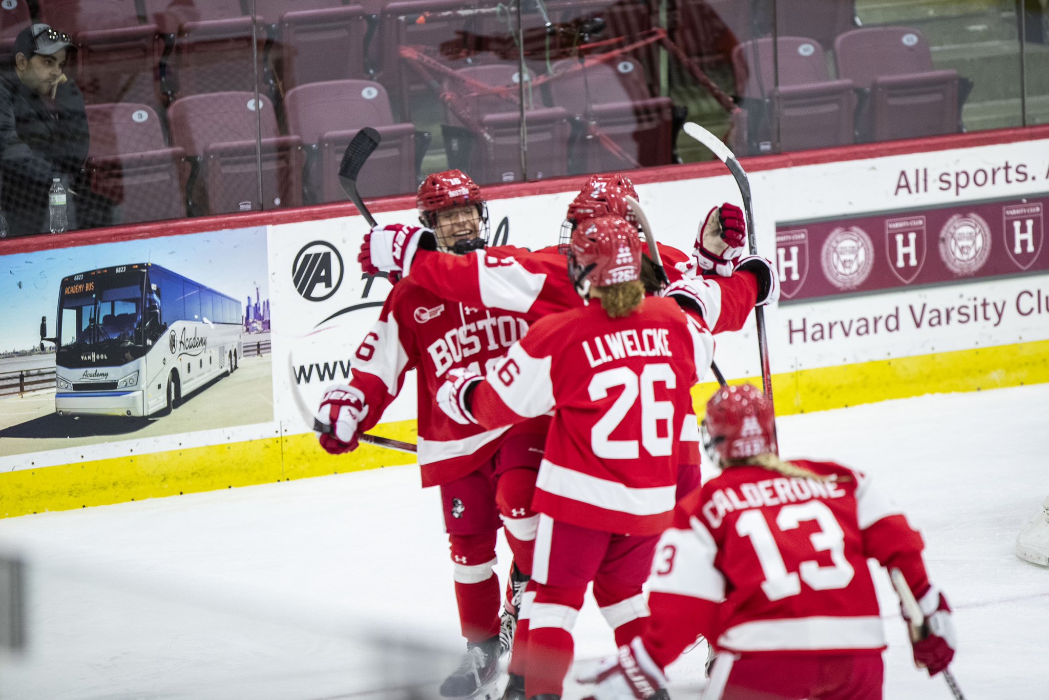 Boston University players, wearing red home uniforms, celebrate a goal against Boston College.