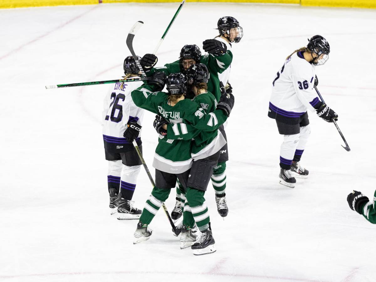 Boston players, wearing green home uniforms, celebrate the first goal in franchise history.