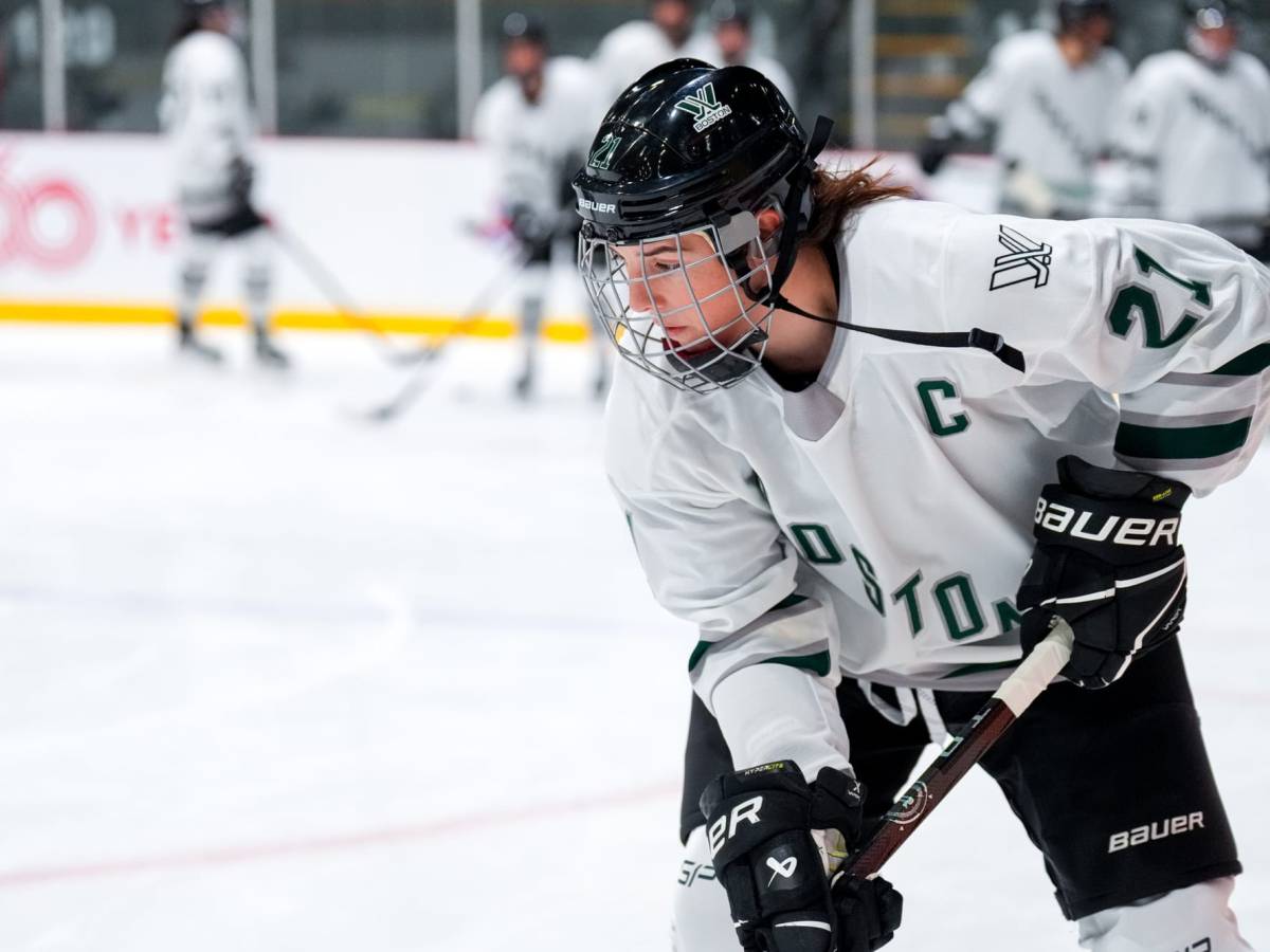 Hilary Knight, wearing a white away jersey, handles the puck during warm-ups.