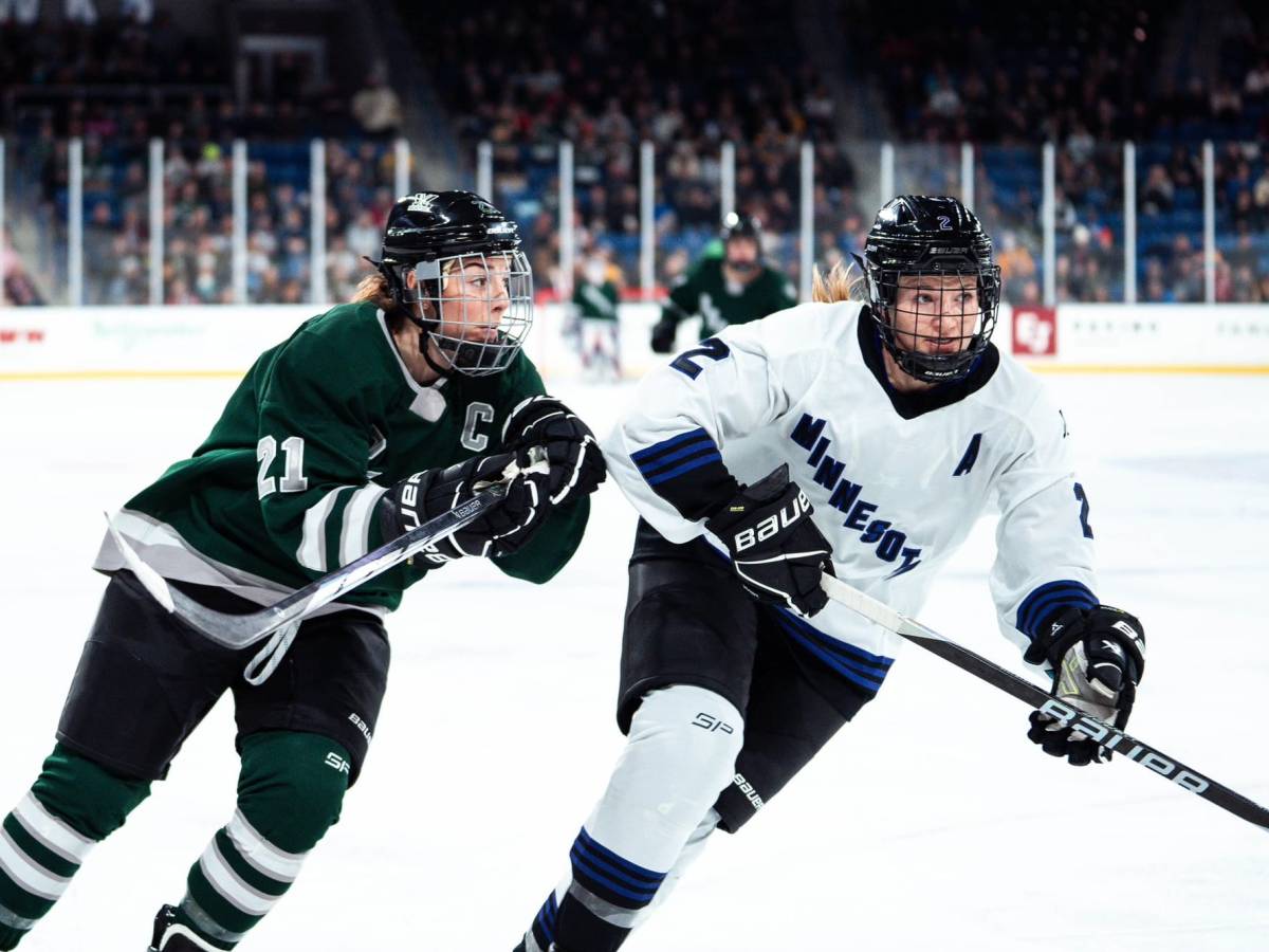 Hilary Knight and Lee Stecklein skate towards a loose puck.
