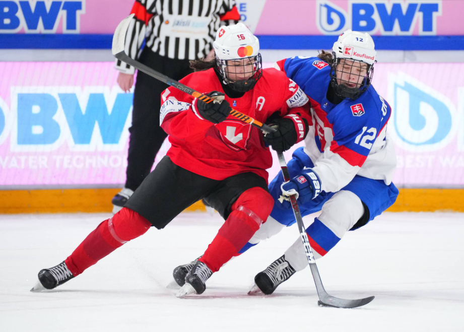 Nela Lopušanová is leaned on while holding the puck