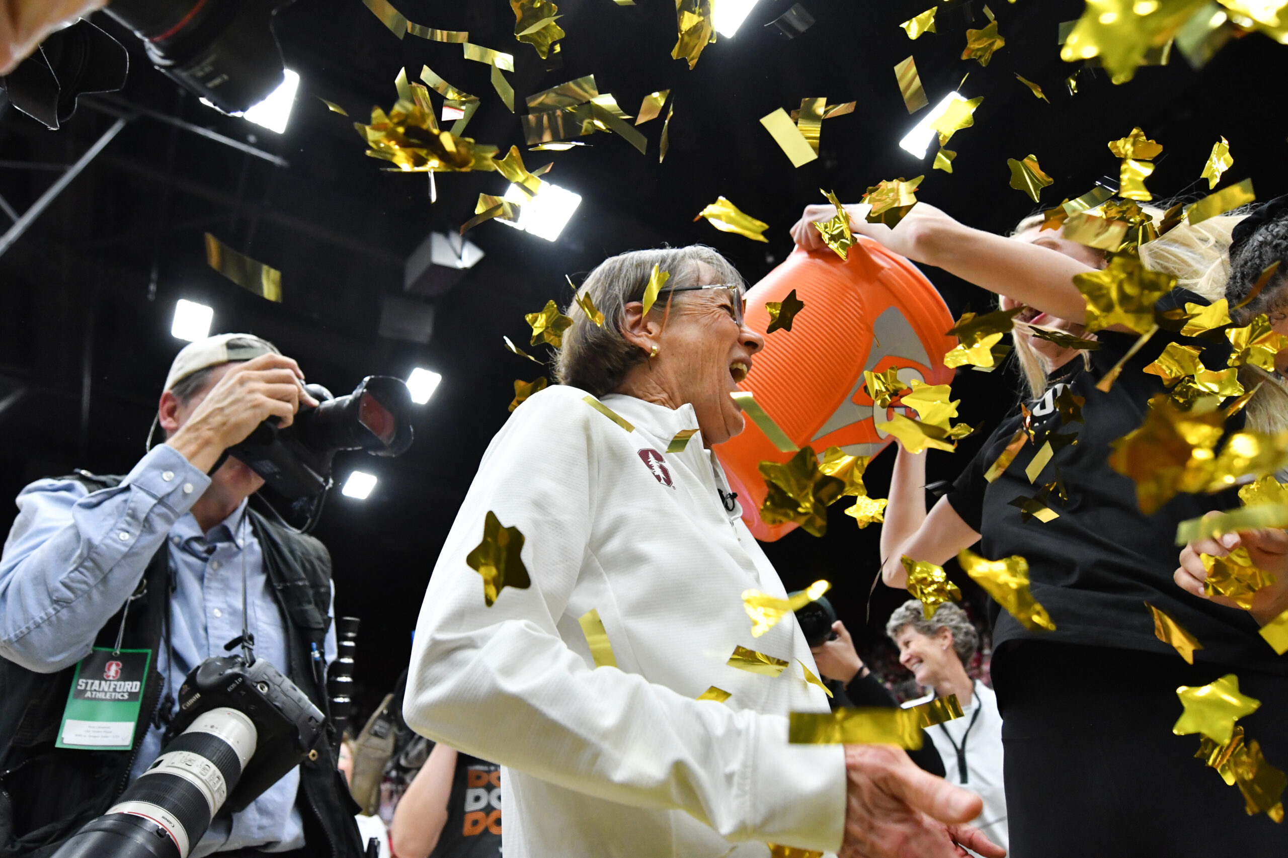 Stanford coach Tara VanDerveer is covered in confetti as her team celebrates her 1,203 win as head coach.