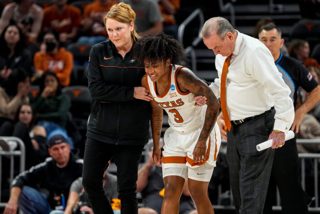 Texas Longhorns guard, Rori Harmon (3) helped off the court after a leg injury in the fourth quarter of the women’s NCAA playoff game against Louisville at the Moody Center on Monday Mar. 20, 2023 in Austin.