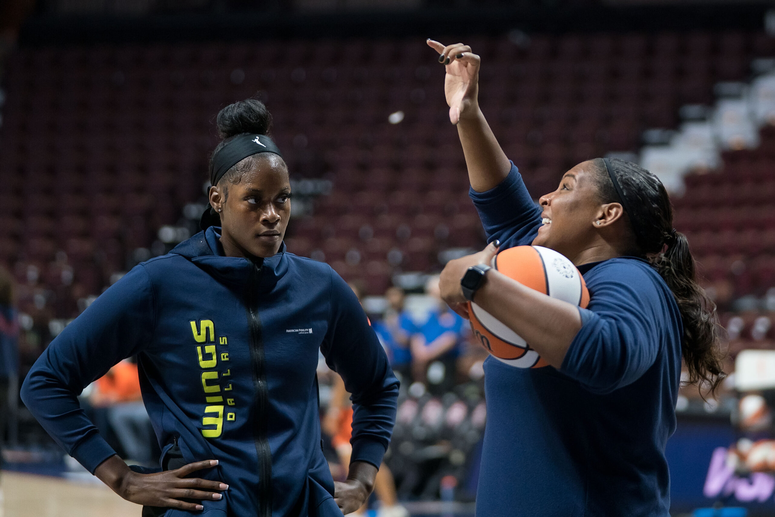 Kalani Brown listens to Dallas Wings assistant coach Courtney Paris