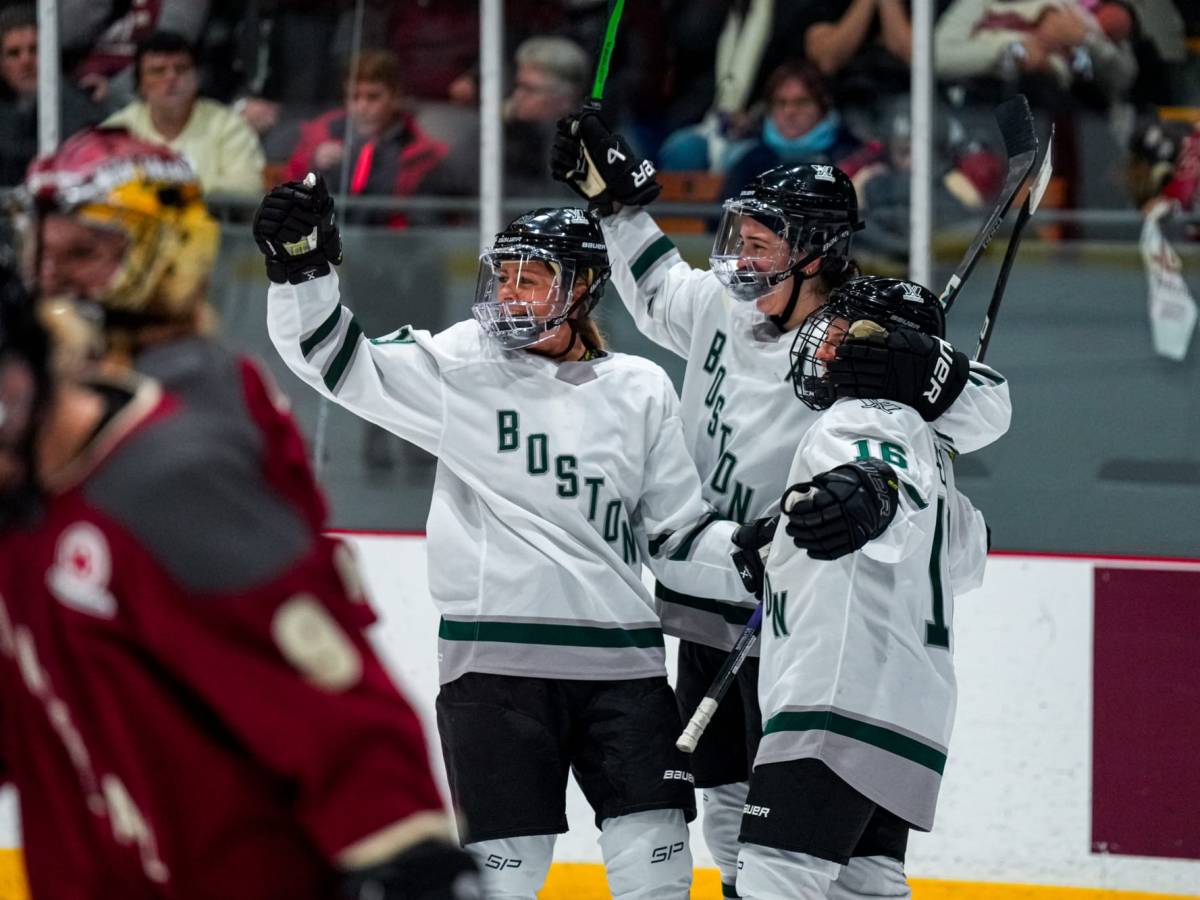Wearing their white away uniforms, Boston players celebrate Amanda Pelkey's overtime winner with her against Montréal.