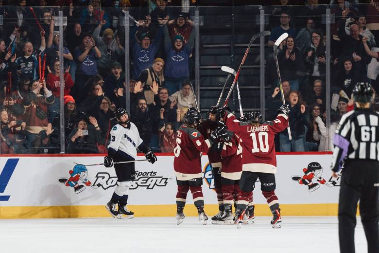 Montréal players, wearing their maroon home jerseys, celebrate a goal against Minnesota.