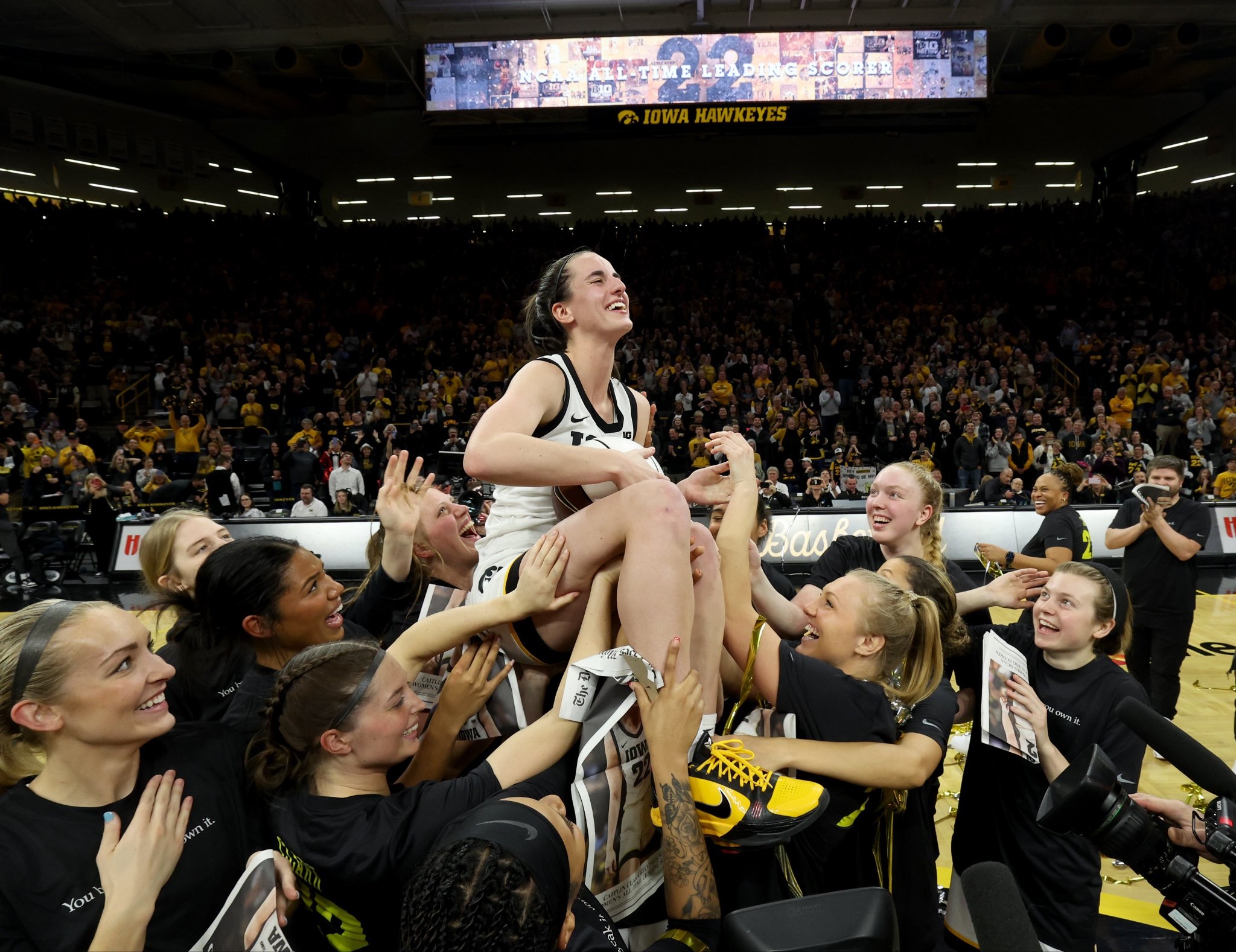 Caitlin Clark (22) is hoisted in the air by her Iowa Hawkeye teammates after setting the NCAA Division I women's basketball scoring record Thursday, Feb. 15, 2024, at Carver-Hawkeye Arena in Iowa City. PHOTO CREDIT/hawkeyesports.com