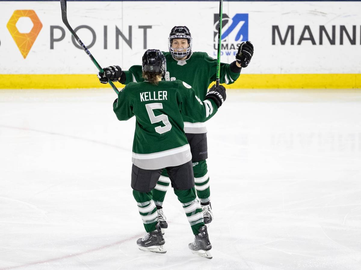 Megan Keller and Taylor Girard celebrate a goal during a previous game. Both players are wearing their green home uniforms.