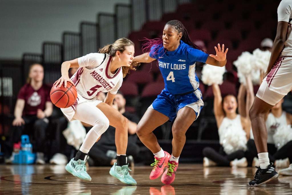 UMass' Kristin Williams looks to drive while dribbing with her right hand. Saint Louis' Kennedy Calhoun slides her feet as she tries to defend her A-10 rival.