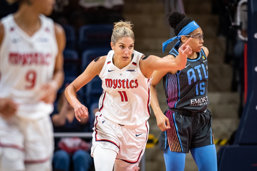 Washington Mystics forward Elena Delle Donne points ahead of her with her left hand as she runs down the court.