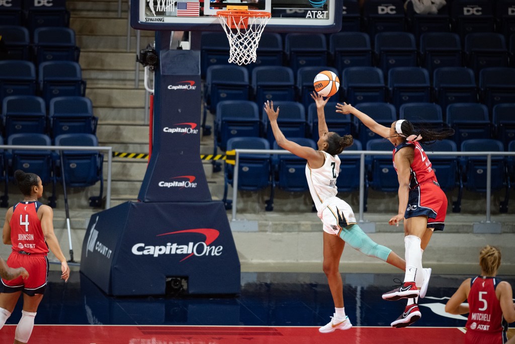 New York Liberty guard/forward DiDi Richards shoots a right-handed layup as Washington Mystics forward Erica McCall leaps in an unsuccessful effort to block the shot from behind.