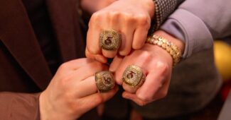 Members of the Toronto Six hold up their championship rings with the team logo