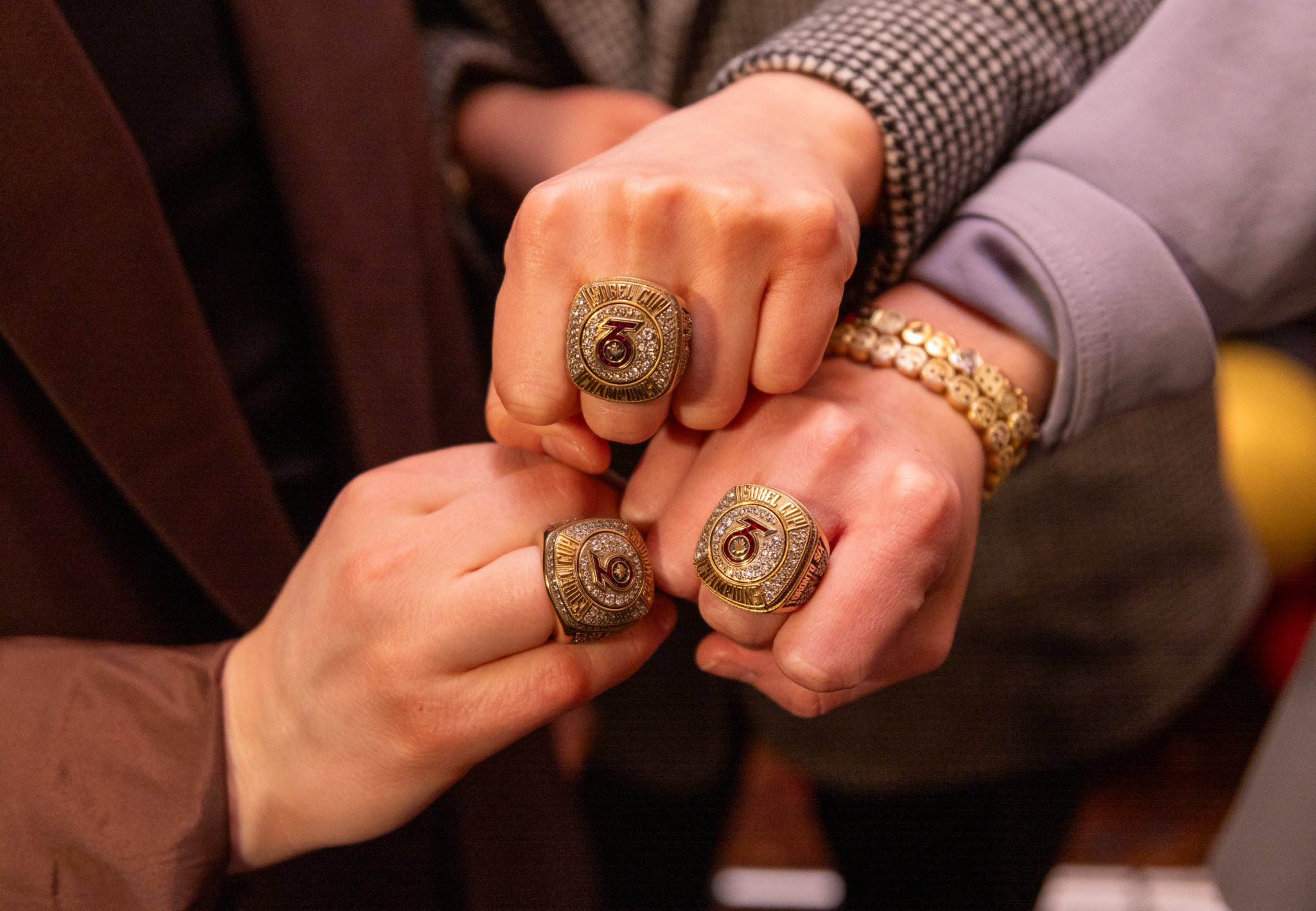 Members of the Toronto Six hold up their championship rings with the team logo
