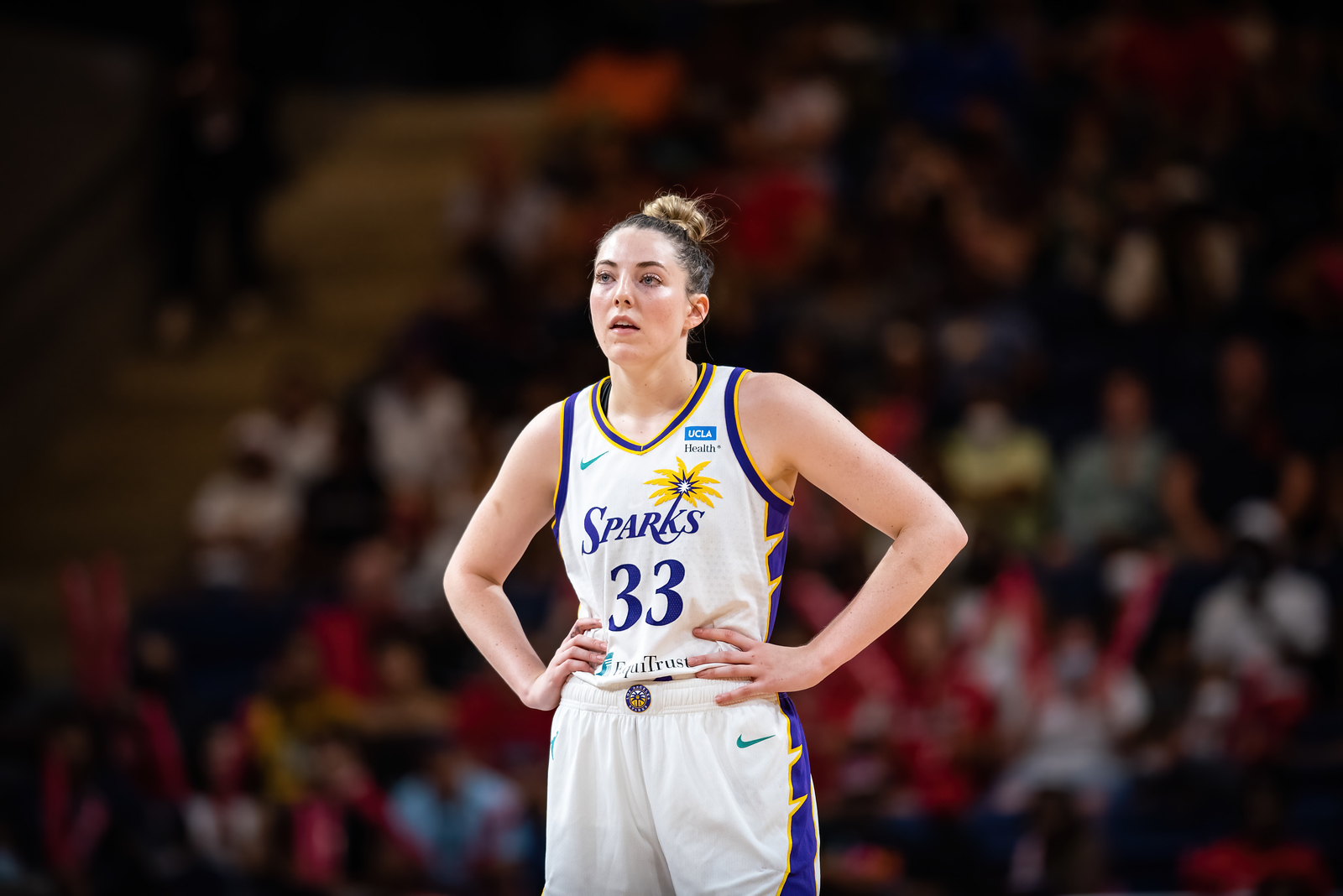 Los Angeles Sparks forward Katie Lou Samuelson stands with both hands on her hips and looks into the distance.