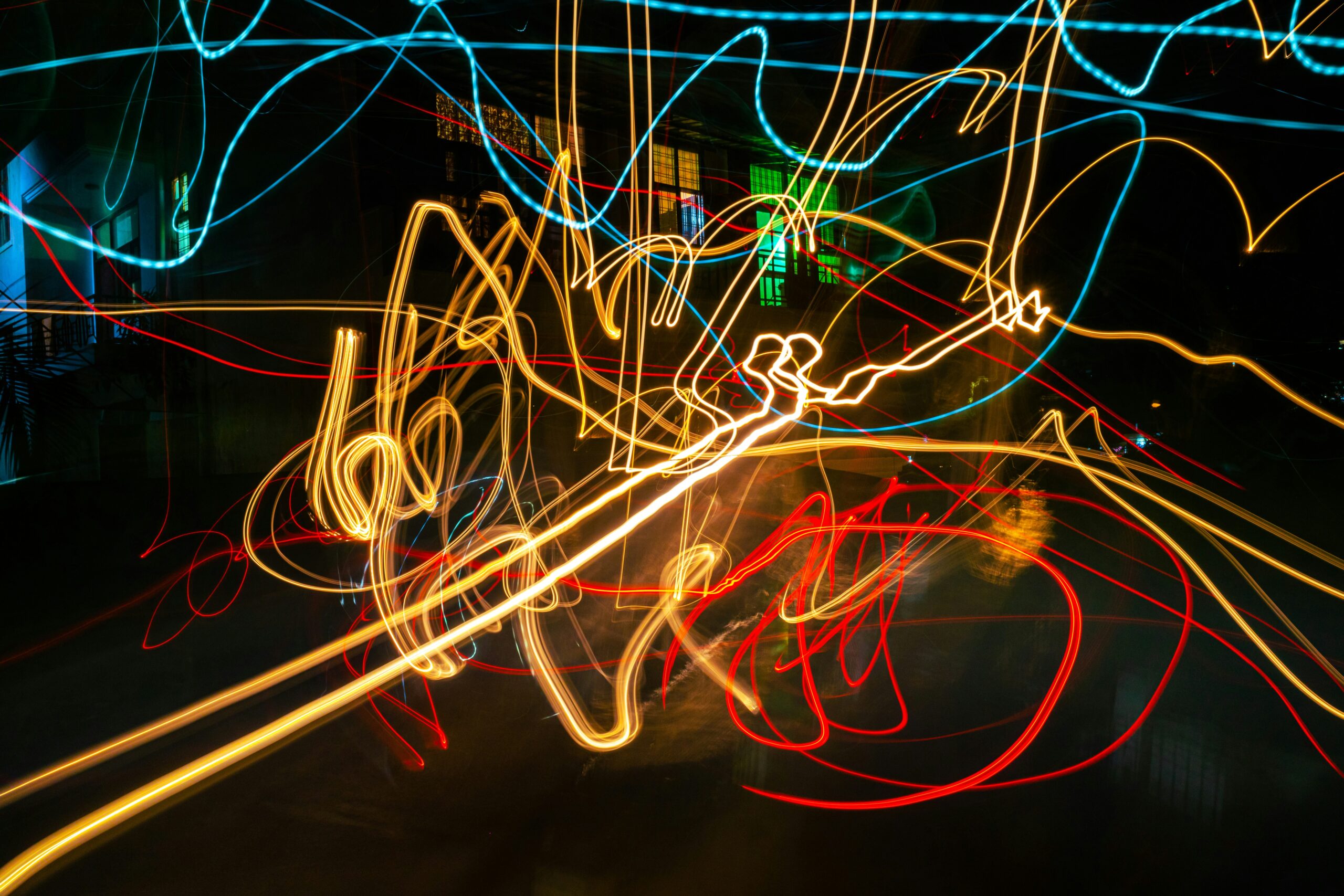 A photo of streaks of light criss-crossing through space, taken from a long exposure camera shot.