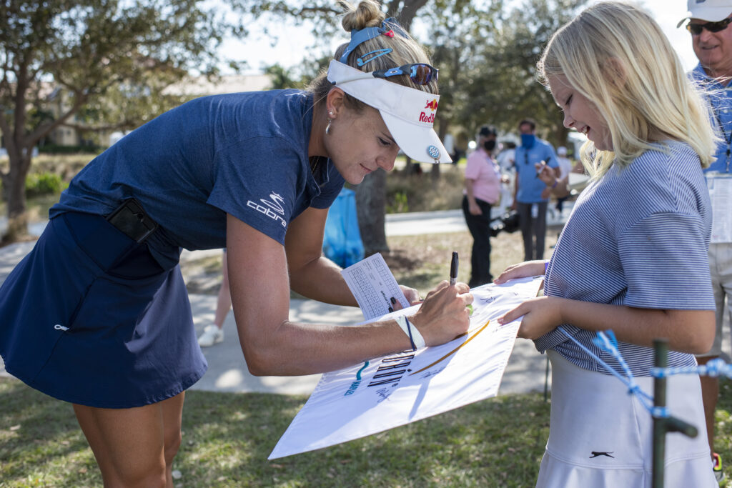 Lexi Thompson signs an autograph for a young fan.