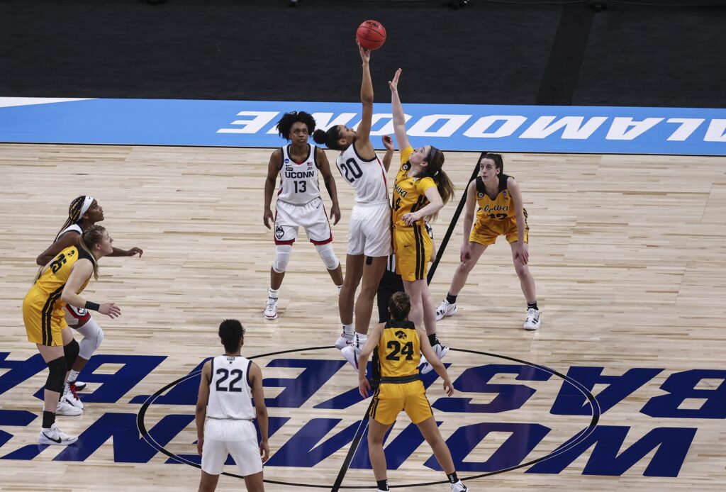 Mar 27, 2021; San Antonio, Texas, USA; UConn Huskies forward Olivia Nelson-Ododa (20) and Iowa Hawkeyes guard McKenna Warnock (14) battle for the opening tipoff during the first quarter in the Sweet Sixteen of the 2021 Women's NCAA Tournament at Alamodome. Mandatory Credit: Troy Taormina-USA TODAY Sports