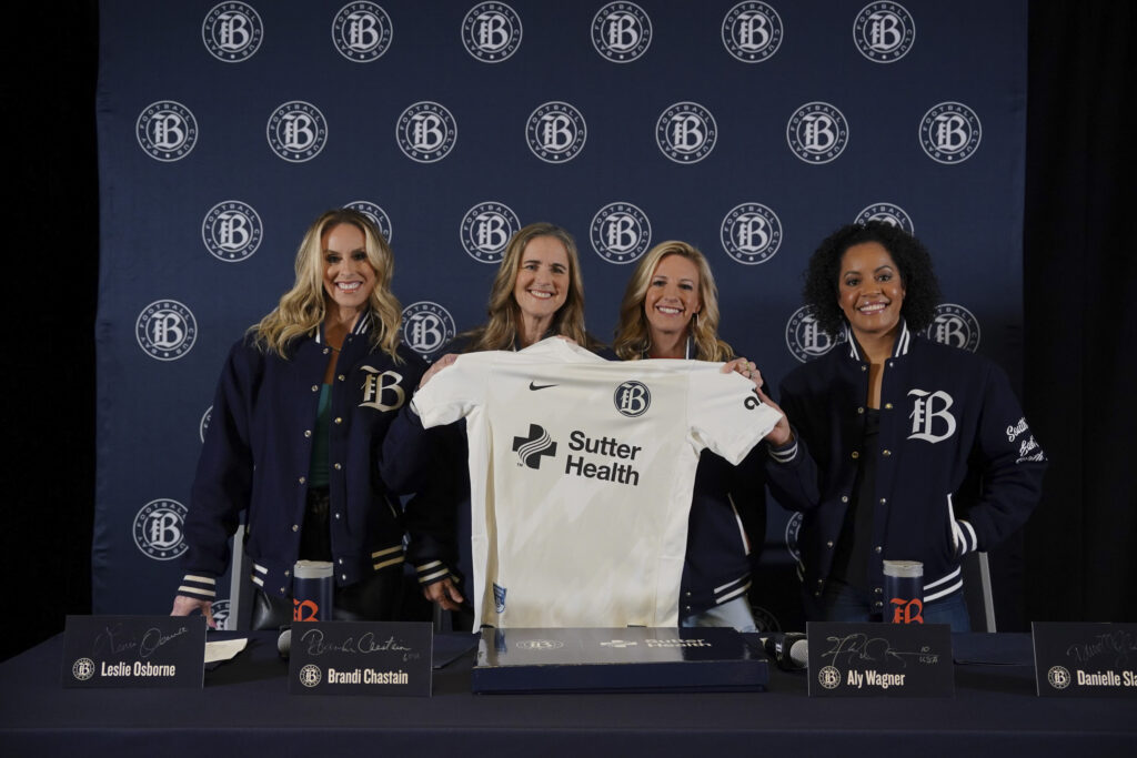 Bay FC co-founders pose for a photo with a team jersey at the club's inaugural kit announcement. Beattie