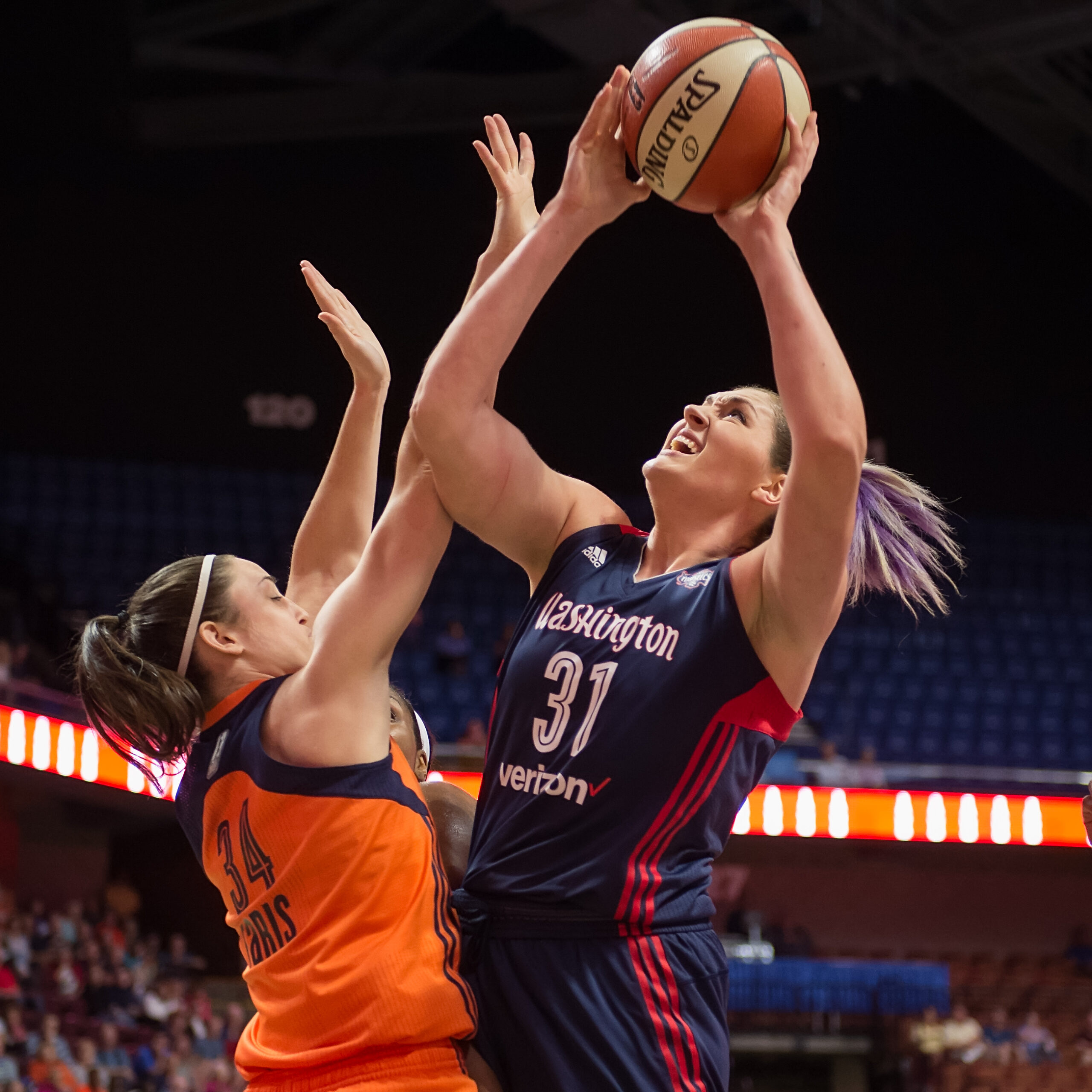 Washington Mystics center Stefanie Dolson attempts a shot through contact from Connecticut Sun guard Kelly Faris.