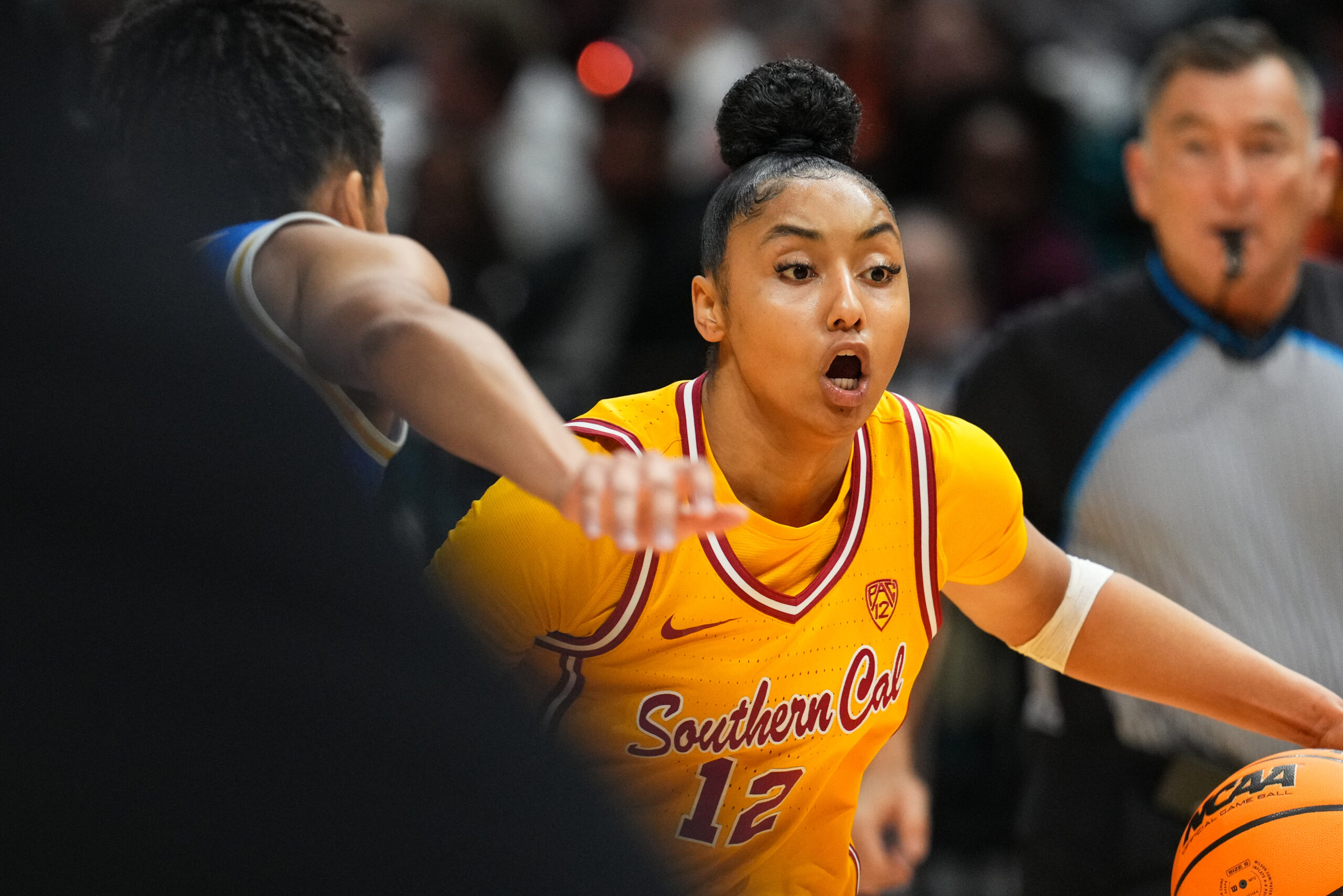 USC star JuJu Watkins shouts instructions as she dribbles the ball with her left hand under pressure.