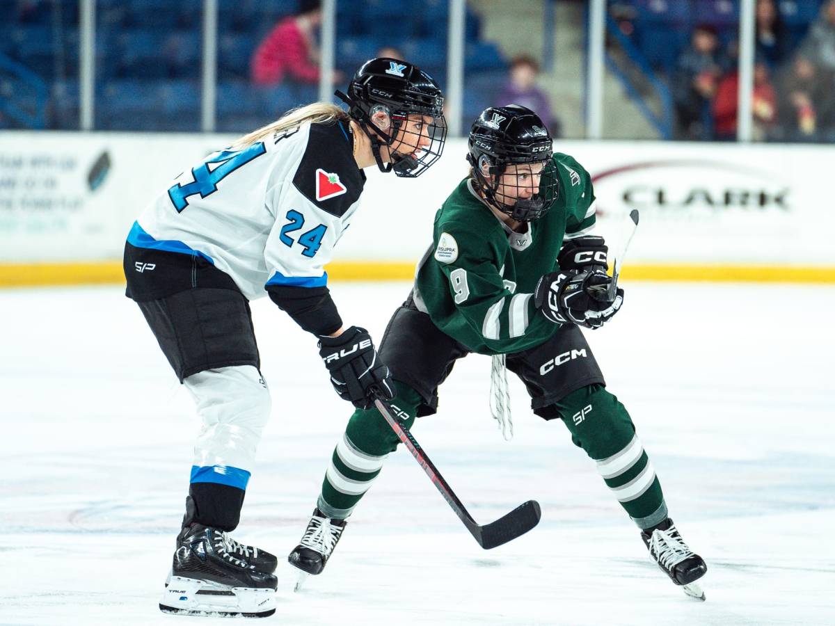 Sophie Shirley and Natalie Spooner prepare to make a play on the puck. Shirley is in green, while Spooner is in white.