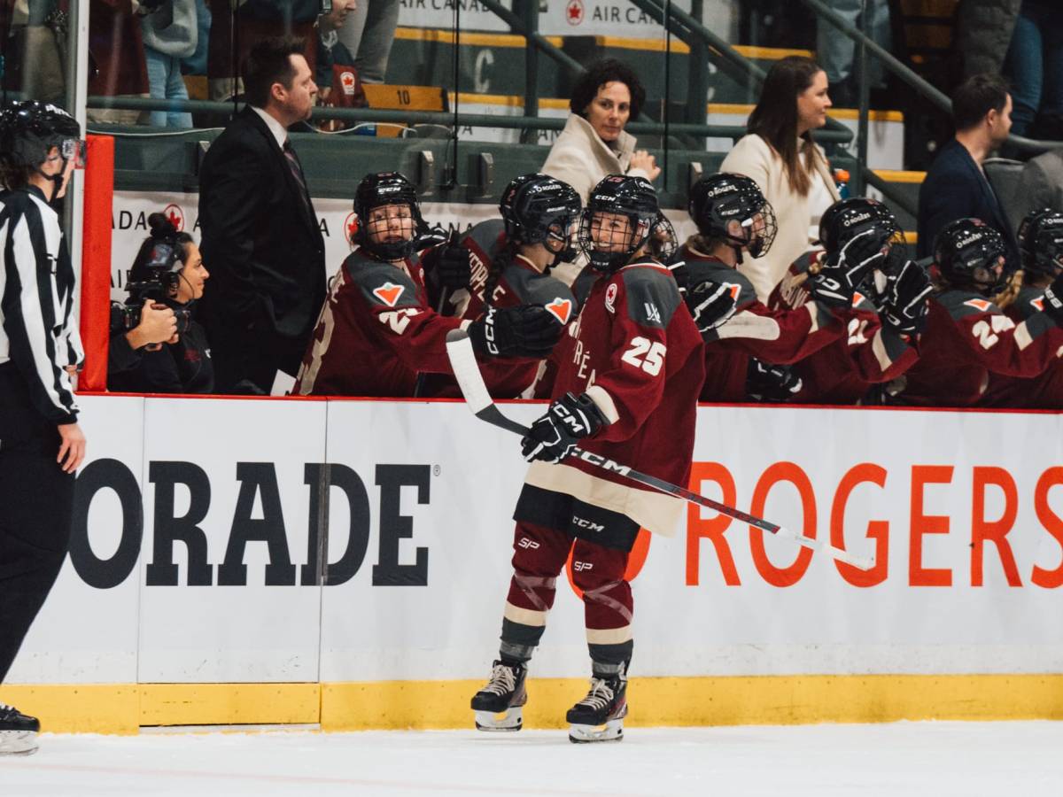 Mélodie Daoust celebrates her goal against Boston. She is going down the bench handshake line in a maroon home uniform.