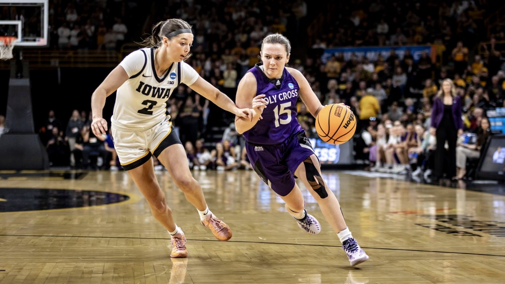 Holy Cross forward Cara McCormack drives against Iowa guard Taylor McCabe in their NCAA Tournament first-round matchup