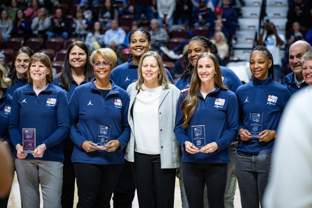 BIG EAST Legends stand on the court holding plaques