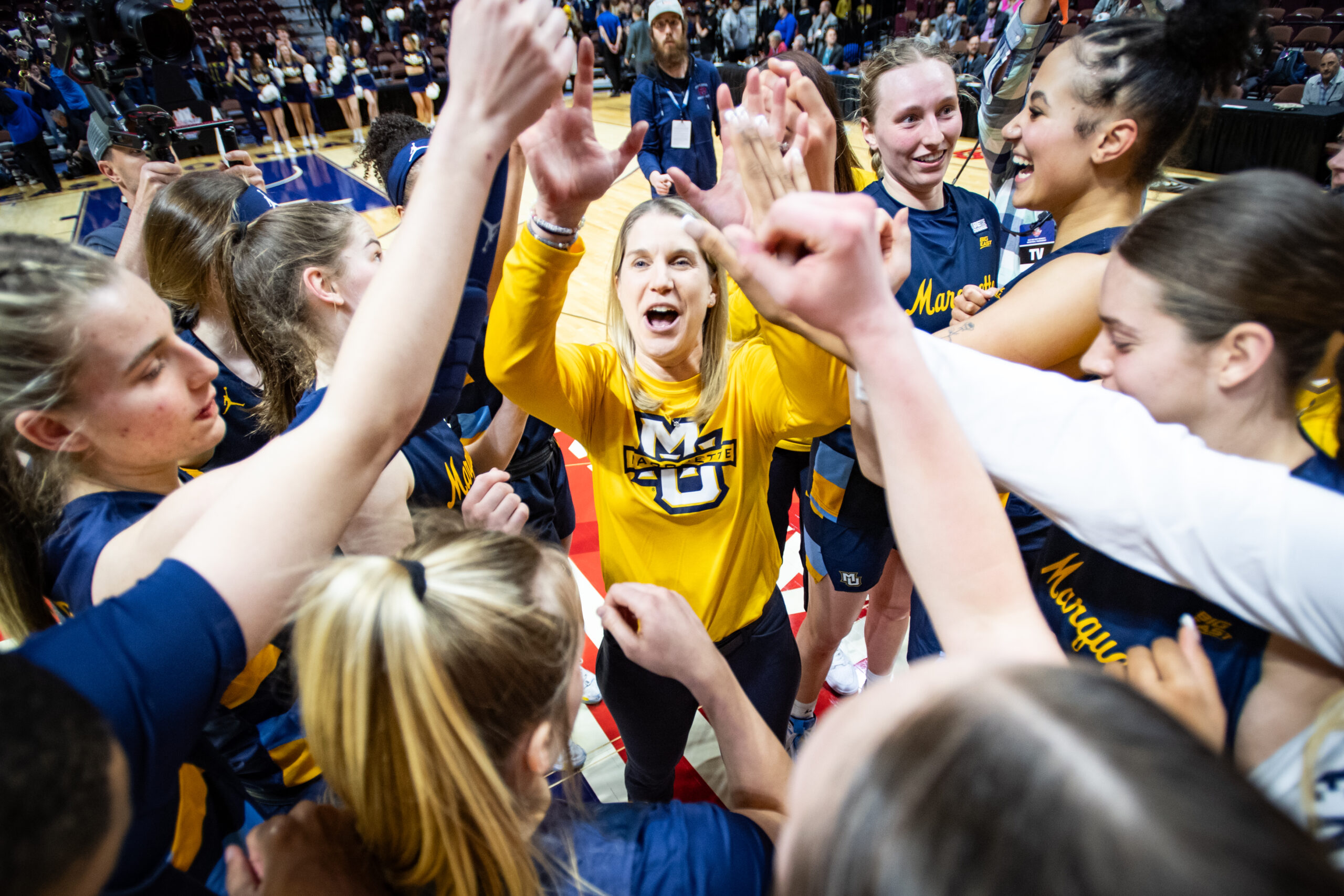 Marquette players gather in a celebratory huddle around head coach Megan Duffy after a BIG EAST Tournament quarterfinal win