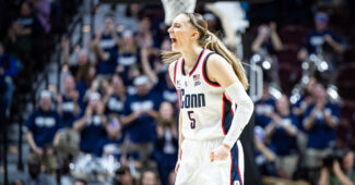 Paige Bueckers screams in celebration in a solo shot of her on the court.