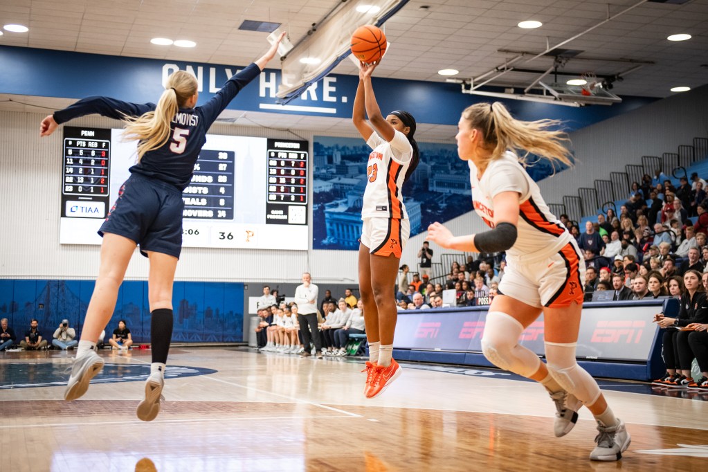 Princeton guard Madison St. Rose shoots a jump shot as a Penn defender can't contest it in time. Princeton forward Ellie Mitchell (right) runs toward the rim from near the baseline.